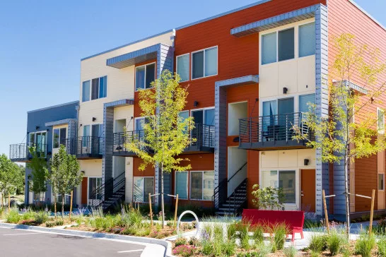 Outside photo of a colorful multi-family housing complex.