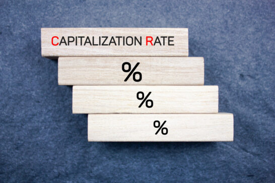 Stacked wooden blocks with 'CAPITALIZATION RATE' text, symbolizing multifamily cap rates